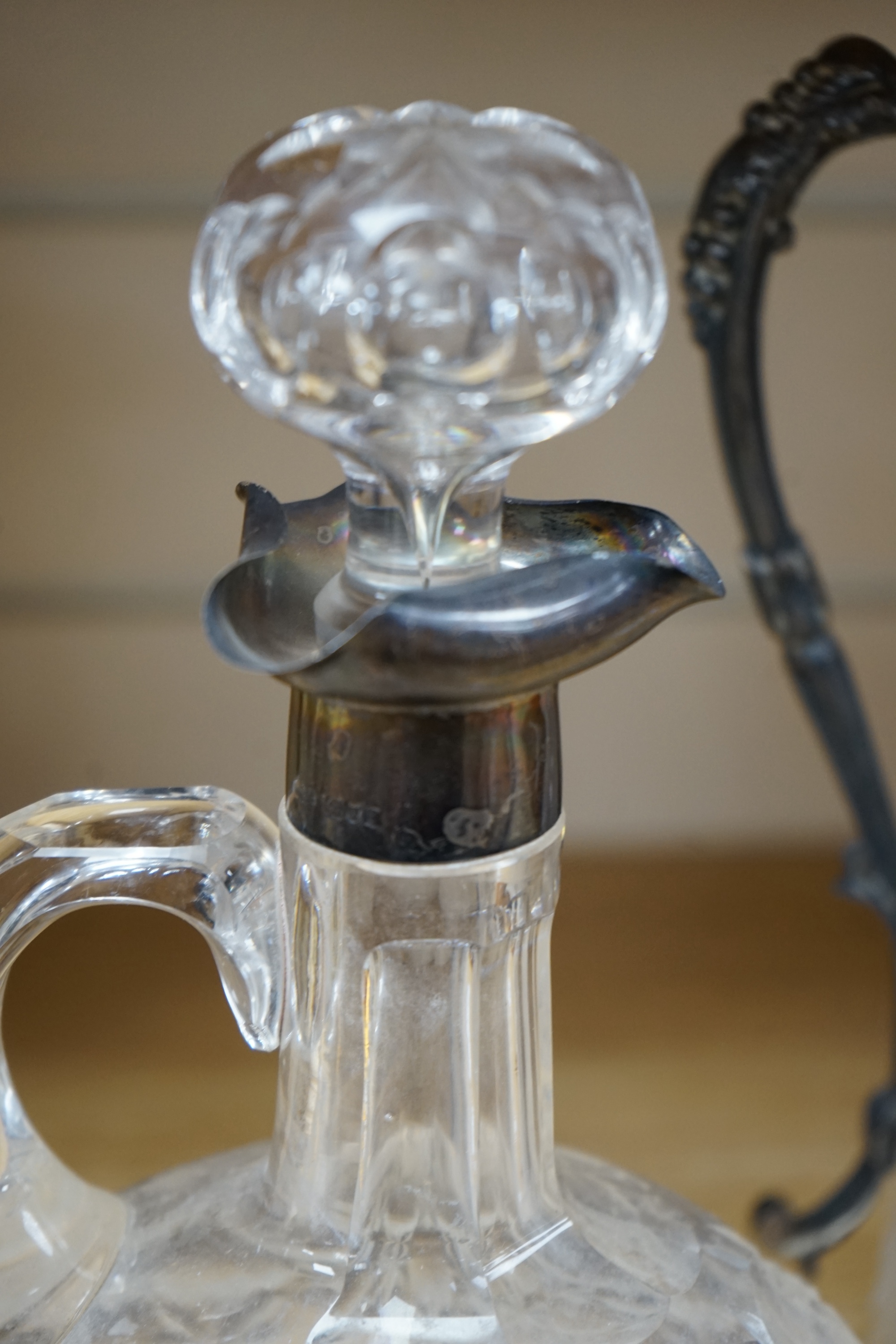 An Edwardian silver mounted cut glass decanter and stopper, London, 1901, height 26cm, together with a silver plate mounted cut glass claret jug. Condition - poor to fair